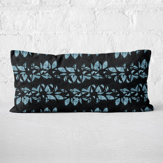 Lumbar pillow featuring an abstract black and aqua floral lei pattern